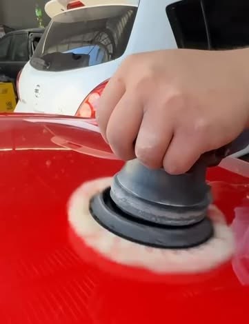 Polimento profissional em carro vermelho, boina em ação sobre a lataria